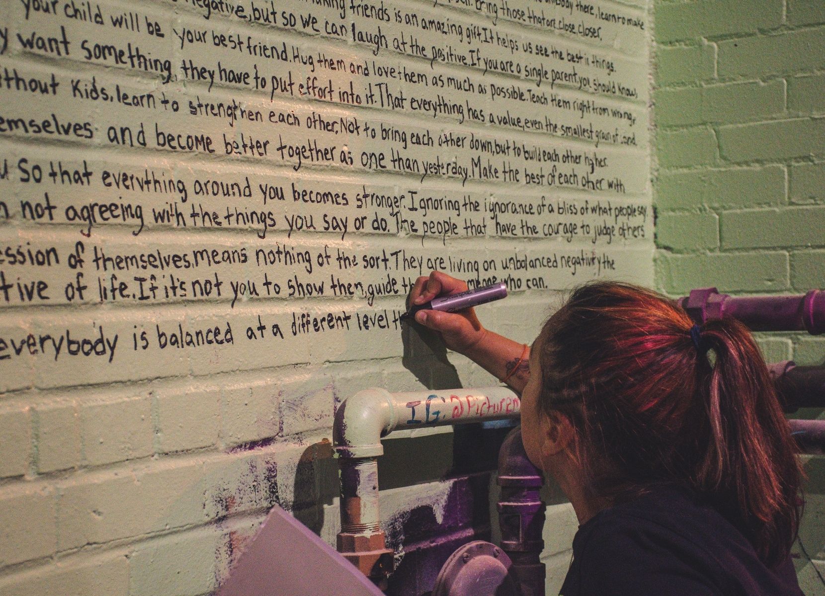Een meisje die tekst op de muur aan het schrijven is